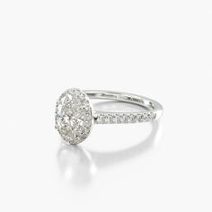 an oval shaped diamond engagement ring on a white background with the center stone set in 18k white gold