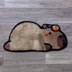 a rug with a dog laying on it's back in front of a wooden floor