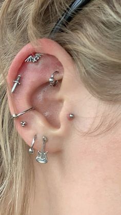 a close up of a person with ear piercings on their ears and behind the ear