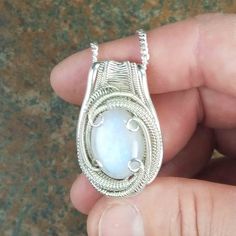 "You want it and you know who you are. This Rainbow Moonstone pendant is wire wrapped in sterling silver. Moonstone holds within it the deep seated nature of feminine energy, which is said to help balance the masculine-feminine vibrations within your body and nurture your spirit. I'm offering this amazing piece together including chain for only 250. 📖 A 𝗹𝗲𝗴𝗲𝗻𝗱 𝗳𝗿𝗼𝗺 𝗦𝗿𝗶 𝗟𝗮𝗻𝗸𝗮 says that a moon like stone occurred deep in the earth, and that on a night like this when the moon was White Wire Wrapped Round Pendant Jewelry, White Wire Wrapped Pendant Jewelry, White Sterling Silver Wire Wrapped Jewelry, White Sterling Silver Wire Wrapped Necklaces, Sterling Silver Wire Wrapped White Necklace, Spiritual Wire Wrapped Sterling Silver Jewelry, Sterling Silver Wire Wrapped Jewelry For Anniversary, Sterling Silver White Wire Wrapped Necklace, White Sterling Silver Wire Wrapped Necklace