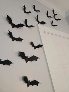 a bunch of bats are hanging on the wall in front of an open white door