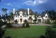 a large white house surrounded by lush green trees