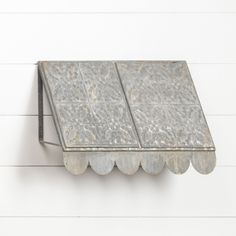 a metal shelf on the side of a white wall