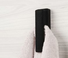 a black towel hanging on the side of a white wall