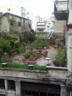 an old building with lots of plants growing on the roof