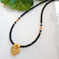 3mm black Tourmaline choker and matte gold Bohemian glass beads with an old gold heart pendant. MEASURES 35, 40, 45, 50, 55 and 60 cm. + 5cm extender.  There is the possibility of removing the extender in case you do not want it. Contact me to detail your request  💎M A T E R I A L S - Black Tourmaline beads 3mm.   The stones are natural so they will never be the same as each other. - 3mm gold Bohemian glass beads. - Old gold heart pendant. - Stainless steel closures. - Unbreakable steel thread for linking beads. 📦PACKAGING Very nice packaging ready to give away if desired. - Navy blue box with the logo (measured according to the size of the jewel). - Light brown natural linen burlap bag, VIP card with 15% discount,    wipe to clean the jewel and some delicious sweets. - Padded bag for pr Elegant Black Heart Pendant Choker, Elegant Gold Choker With Heart Charm, Elegant Black Heart-shaped Choker, Spiritual Black Heart-shaped Necklace, Spiritual Black Heart-shaped Necklaces, Beads Packaging, Black And Gold Necklace, Black Tourmaline Necklace, Elegant Choker