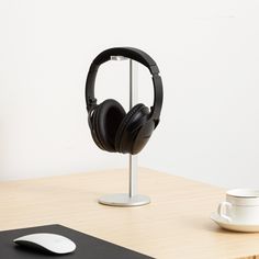 a pair of headphones sitting on top of a table next to a cup and saucer