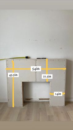 a white table with yellow tape on it and measurements for the top shelf in front of it