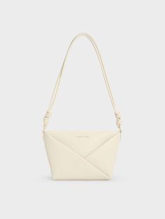 This product is made with at least 20% sustainable materials by weight. CHARLES & KEITH uses recycled, degradable, organic, and water-based materials in our eco-conscious collection. Offering versatility in a visually interesting silhouette, this Midori crossbody is the perfect accessory to enliven any outfit. The sleek cream finish lets the clean, elegant lines of the geometric folds stand out, giving the minimalist design a pleasing tactility. The knotted details on the strap are understated yet distinctive. Fitted with a zip closure that will keep your belongings secure, this stylish and practical bag can be carried on the shoulder or across the body. Clear Backpacks, Charles And Keith, White Shoulder Bags, Chic Crossbody Bag, Practical Bag, Size Chart For Kids, Charles Keith, Black Crossbody, Black Cross Body Bag