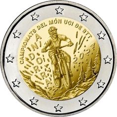 a gold and silver coin with the image of a man on a bike