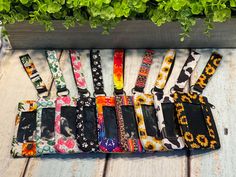 the dog collars are lined up on the wooden table next to flowers and plants