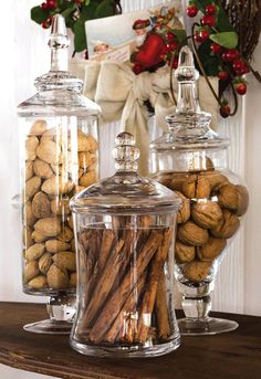 three glass jars filled with nuts on top of a table