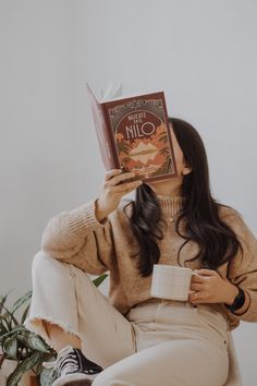 a woman is sitting down and reading a book