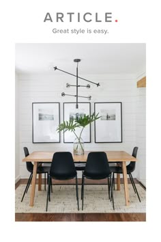 a dining room table with black chairs and two framed pictures on the wall above it