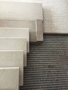 a close up of some steps on a tiled floor with perforated metal grates