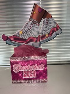 a pair of sneakers that are on top of a pink box with the words sneaker ball