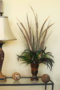 two vases with plants on a table next to a lamp and other decorative items