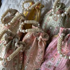 "These rich hand made artisanal Indian potli bags are embroidered on a dupion fabric, and are in a round \"bucket-esque\" shape. Though these bags can be used in place of a traditional clutch bag, they also make for a fantastic low-waste gift packing solution for weddings and life's other special events. This potli is embroidered all the way round, measures approximately 9x7 inches, and features a pearl embellished handle - resulting in a super rich luxurious look with a traditional twist Questi Luxury Traditional Potli Bag With Pearl Embroidery, Luxury Bohemian Potli Bag For Festive Season, Cheap Rectangular Potli Bag For Festivals, Luxury Pearl Embroidered Bags For Gifts, Pakistani Wedding Fevors Bids Dulha Dulhan. Dray Fruit Bags Dllls Dress Bag, Luxury Potli Bag With Mirror Work For Festivals, Luxury Festive Potli Bag With Mirror Work, Luxury Pearl Embroidered Potli Pouch Bag, Luxury Elegant Potli Bag In Pouch Shape