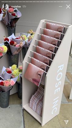 there are many vases with flowers in them on the display stand, and one is open