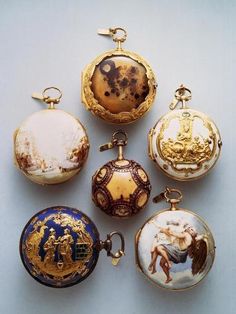 an assortment of antique pocket watches with paintings on the front and sides, all in different colors