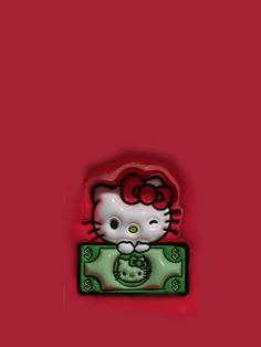 a hello kitty pin sitting on top of a pile of money in front of a red background