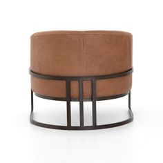 a brown leather ottoman sitting on top of a white floor next to a black metal frame