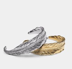 Feather Bundle for Men - Gold & Silver Plated Stainless Steel, Hand-Etched Detailing, Adjustable Cuffs, Perfect Gift for Him The Feather Bundle includes Elegatto's best-selling Feather Gold and Feather Silver bracelets. These cuffs are made from marine-grade stainless steel, plated in S925 sterling silver and 18k gold, with exquisite hand-etched detailing. Both bracelets fit smoothly onto the wrist and are easily adjustable. The feather signifies inspiration and freedom, also symbols of travel - both mind and body. This bundle is a perfect gift for the free spirit in your life who desires to soar higher and further. Bracelets come in the Elegatto original box, silk soft jewelry pouch, and a quality card. Key Features: Premium Materials: Marine-grade stainless steel, plated in S925 sterling Feather Cuff Bracelet, Feather Cuffs, Gold Feathers, Perfect Gift For Him, Jewelry Pouch, Bracelet Sizes, Free Spirit, Silver Bracelets, Gift For Him