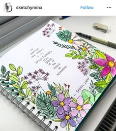 an open notebook with flowers and leaves on it