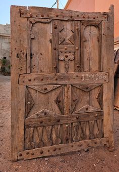 an old wooden door with carvings on the front and back doors are made out of wood