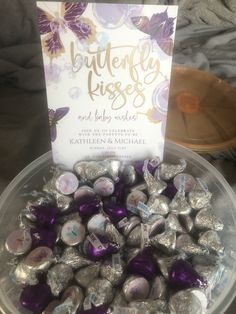 a plastic container filled with chocolate candies and a sign on top that says, butterfly kisses and baby wishes