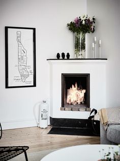 a living room with a fire place and pictures on the wall