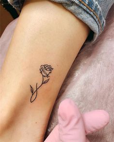 a small rose tattoo on the left side of the leg, with one flower in it's center