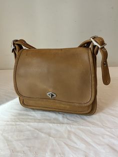 Vintage Coach Rambler Tan Leather Legacy Shoulder Crossbody Bag 9061. You can see the amazing quality of the leather of this bag. In great condition. There is a small ink mark inside the pocket, but it doesn't show on the outside. See pictures, as any problems will be shown in the pictures. Size: 9"  X 8"  X 3" W ITEM IN PICTURE IS WHAT YOU WILL RECEIVE Shipping: I provide free shipping insured by USPS. I am not responsible for any item after it is with USPS. Returns: I accept returns, but the buyer must pay for return shipping regardless of the reason for return. Items must be returned within 14 days of receipt. Combined shipping: I am happy to combine shipping for multiple purchases for free. Classic Everyday Carry Saddle Shoulder Bag, Classic Saddle Shoulder Bag For Everyday Carry, Classic Saddle Bag With Adjustable Strap For Everyday, Classic Shoulder Saddle Bag For Everyday Carry, Classic Saddle Flap Bag For Everyday Use, Classic Bags For Everyday Carry, Classic Everyday Saddle Flap Bag, Classic Flap Saddle Bag For Everyday Use, Classic Soft Leather Saddle Bag For Travel