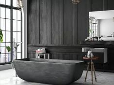 a bathtub sitting in front of a window next to a table and stools