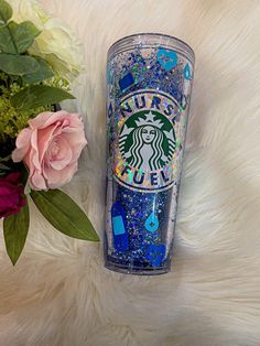 the starbucks cup is next to some flowers