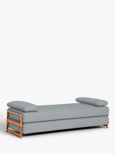 a gray couch with two pillows on it and a wooden frame around the back end