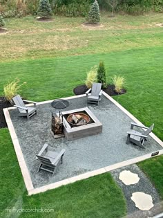 an outdoor fire pit surrounded by lawn chairs and graveled area with trees in the background