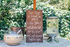 a table topped with drinks next to a sign