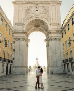 a man and woman standing in front of an arch