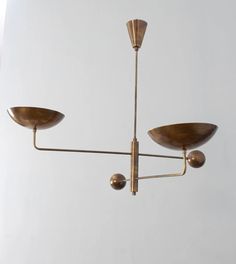 a brass chandelier with three lights hanging from it's arms and two bowls on each end