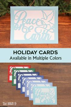 holiday cards available in multiple colors with the peace and earth logo on them, sitting on a wooden table