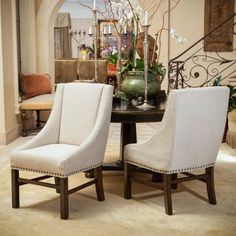 a dining room table with two chairs and a vase on it's centerpiece