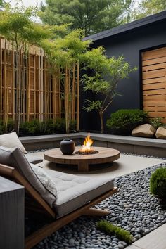 an outdoor fire pit surrounded by gravel and rocks in the middle of a garden area