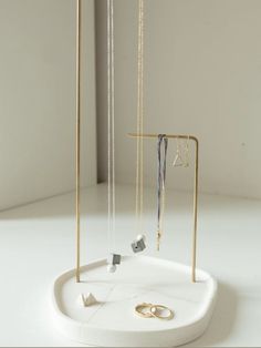 an assortment of jewelry is displayed on a white surface with gold chains and rings hanging from them