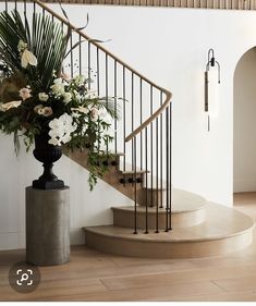 a vase with flowers sitting on top of a set of stairs next to a banister