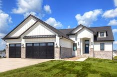 a large house sitting on top of a lush green field under a blue sky with clouds