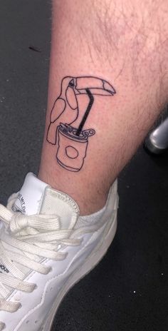 a person with a tattoo on their leg holding a coffee cup and a hammer in it