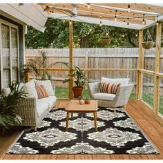 an outdoor patio with wicker furniture and plants