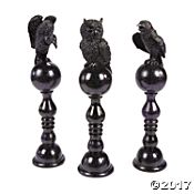 three black candlesticks with owl figurines on them