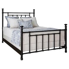 a black metal bed frame with white pillows